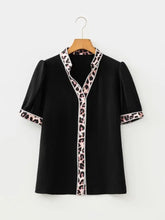 Black short-sleeved puff sleeve blouse with leopard trim puff neckline placket and sleeve cuffs in pink and black