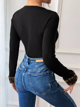 Black long sleeve bodysuit with leopard trim v neck and leopard print cuffs for stylish casual wear