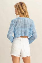 Light blue crochet cropped cardigan with frayed hem and white shorts