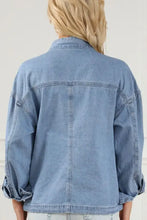 Light blue denim jacket with rolled-up sleeves, button-down front, distressed and lace-up details