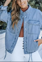 Light blue denim jacket with distressed lace-up details and button-down front