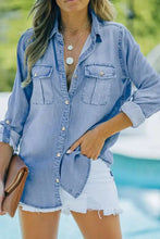 Light blue denim shirt with button-down front, chest pockets, and frayed hem