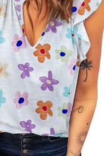 Women’s light blue notched cap sleeve V-neck top with floral print