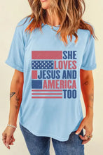 Light blue round neck short sleeve t-shirt with distressed American flag graphic and she loves Jesus and America too text