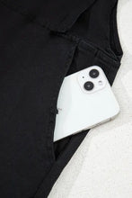 Fehér iPhone 13 a négyzet alakú nyakú farmer kantáros nadrág zsebében
