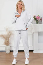 Woman in light gray drawstring sweatpants set with half zip sweatshirt long sleeves