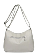 Light grey faux leather crossbody bag with zippered back pocket