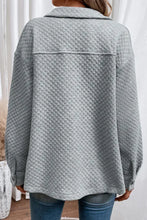 Light gray quilted jacket with long sleeve length and button closure