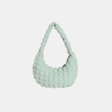 Mint green quilted small texture handbag on display