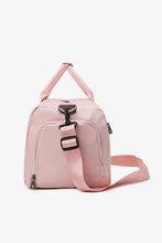 Light pink nylon crossbody duffel bag with strap and buckle