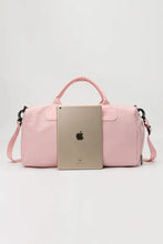 Light pink nylon crossbody duffel bag with adjustable strap