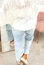 A delicate white lace blouse with sheer flowing sleeves paired with light wash utility pocket straight leg jeans