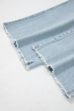 Light wash utility pocket straight leg jeans with frayed distressed hems in light wash denim material