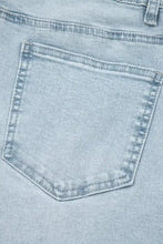 Back side of light wash utility pocket straight leg jeans showing a denim back pocket with reinforced stitching and faded texture