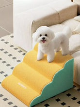 Cheerful white bichon frise atop vibrant yellow teal lightweight pet stairs
