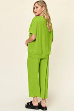 Woman in lime green short sleeve texture round neck top and wide leg pants