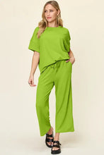 Woman in lime green short sleeve texture round neck top and wide leg pants set