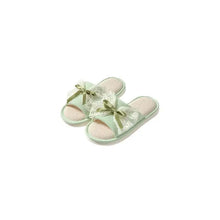 Light green open toe flats with lace trim, bows, and linen material