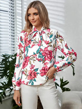 Long sleeve floral blouse with tie neck and bell sleeves on white background