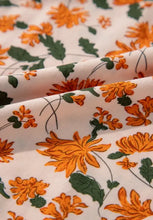 Orange floral print mini dress with green leaves on white background