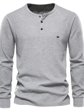 Maglia henley grigia a maniche lunghe con bottoni neri, logo oliva, lavabile in lavatrice, asciugare a bassa temperatura in asciugatrice