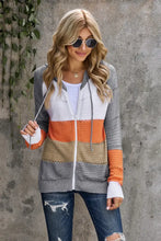Long sleeve multicolored patchwork cardigan sweater with striped zip-up front in orange, gray, and beige