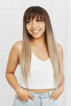 Woman in long straight synthetic wig with ombre brown blonde bangs