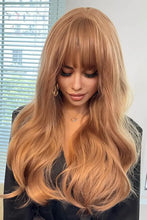 Golden blonde synthetic wig with long wavy layers, bangs, and natural wave