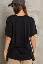 Woman modeling loose fit black V-neck T-shirt with chest pocket in knit slub fabric