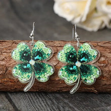 Lucky clover acrylic dangle earrings with green four-leaf clovers and emerald gems