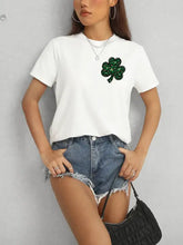 Woman in lucky clover round neck short sleeve t-shirt, denim shorts, black bag