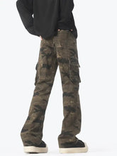 Men’s camouflage cargo jeans in faded olive and dark green camouflage print made of durable denim-like fabric with multiple pockets