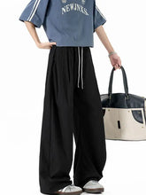 Man in casual wide leg drawstring pants with striped top and duffel bag