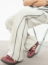 Mens contrast straight sweatpants in off-white with black piping and burgundy sneakers