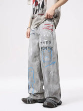 Men’s distressed graffiti print wide leg jeans in gray with spray-painted blue red and black designs including text and faces
