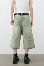 Mens distressed loose denim shorts in light green wash with black belt