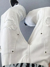 Men’s white distressed raw hem wide leg jeans with frayed patches and metallic rivets in denim material