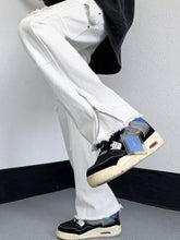 Men’s white denim wide leg jeans with distressed raw hem frayed edges and side zipper detail