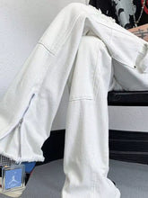Men’s white denim wide leg jeans with distressed raw hem and side zipper detail for a stylish look
