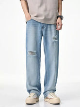 Men’s relaxed fit light-wash denim jeans with distressed frayed patches on knees and thighs