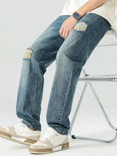 Men’s blue denim relaxed fit jeans with distressed ripped knees and faded wash for casual wear