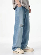 Men’s light-wash denim relaxed fit jeans with distressed frayed tear details on the knees