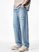Men’s light-wash denim relaxed fit jeans with intentional knee rips and frayed edges in a wide-leg cut