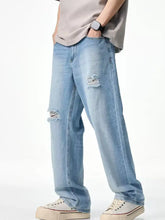 Men’s light-wash denim relaxed fit jeans with intentional distressed rips at the knees and a relaxed fit design