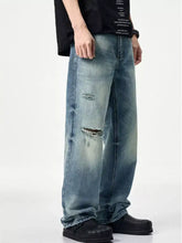 Men’s distressed relaxed fit jeans in light-wash denim with intentional rips and distressed details