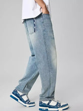 Men’s distressed light-wash denim jeans with a relaxed fit, straight leg cut, and subtle thigh fading
