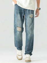 Men’s blue denim relaxed fit jeans with distressed ripped knees and frayed edges for casual wear