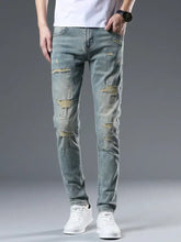 Men’s distressed slim fit jeans in light-wash denim with intentional rips and frayed edges designed for a slim fit look
