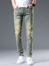 Men’s slim fit distressed olive green denim jeans with paint splatter and ripped details