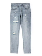 Men’s distressed slim fit light-wash denim jeans with ripped details and subtle white paint splatter accents